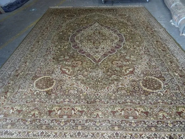 A Persian pattern carpet, machine made with a floral pattern on a green ground, 364cm x 275cm.