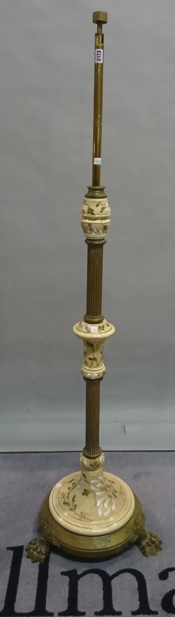 An early 20th century brass standard lamp with a reeded column on claw supports, 153cm high.