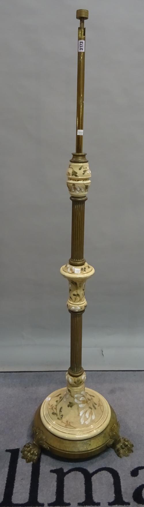 An early 20th century brass standard lamp with a reeded column on claw supports, 153cm high.