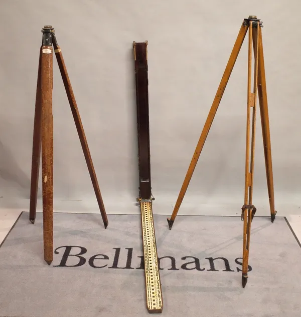 A similar pair of early 20th century hardwood surveyor's tripods 157cm tall, and a large measuring stick, 122cm tall.