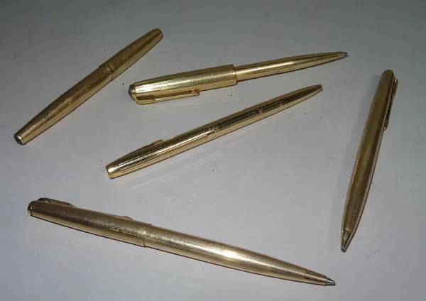 A group of Parker gold plated writing implements, comprising; a fountain pen, two ballpoint pens, (one lacking the finial and pocket clip), a pencil a