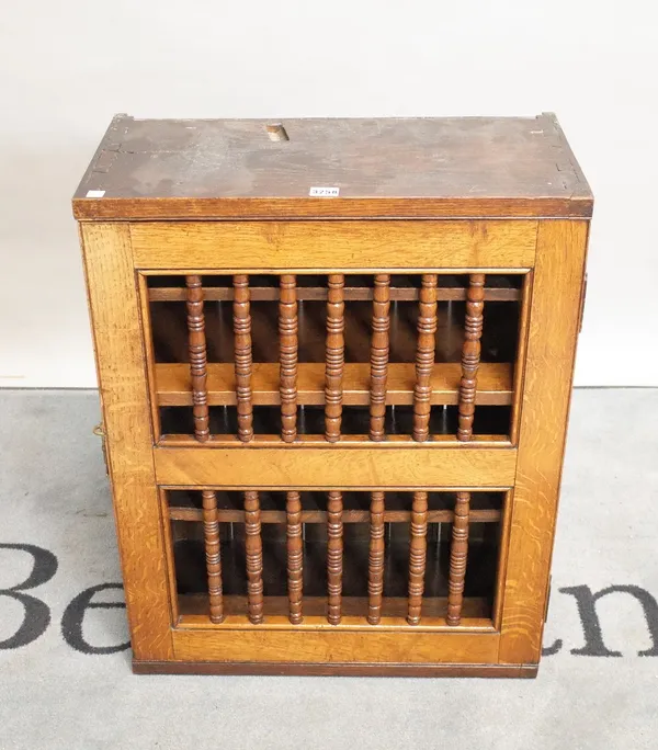 A late 18th century oak wall hanging cupboard with spindle turned decorated door, 57cm wide x 74cm high.