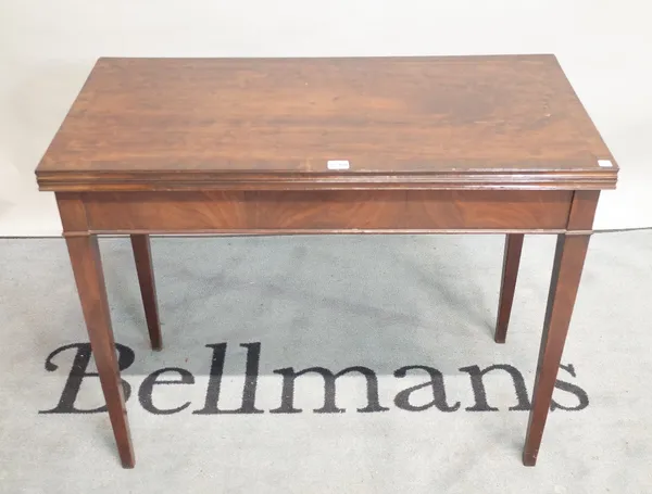 A George III mahogany foldover tea table on tapering square supports, 91cm wide x 74cm high.