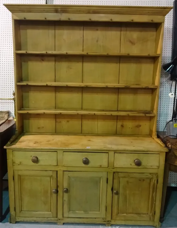 An early 20th century pine kitchen dresser with three tier plate rack over three drawer cupboard base, 152cm wide x 212cm high.