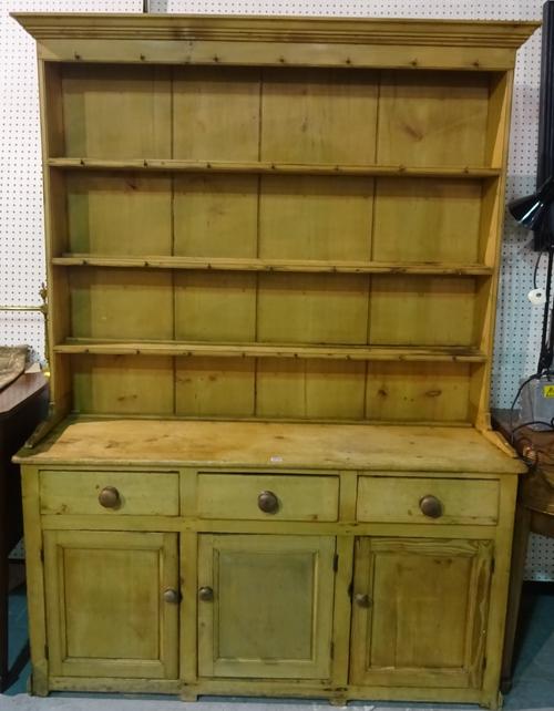 An early 20th century pine kitchen dresser with three tier plate rack over three drawer cupboard base, 152cm wide x 212cm high.