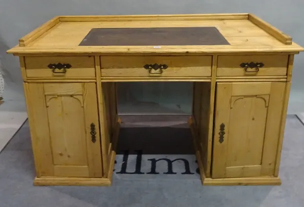 An early 20th century pine writing desk with three frieze drawers over cupboard doors, 138cm wide x 85cm high and a modern pine side table, 63cm wide