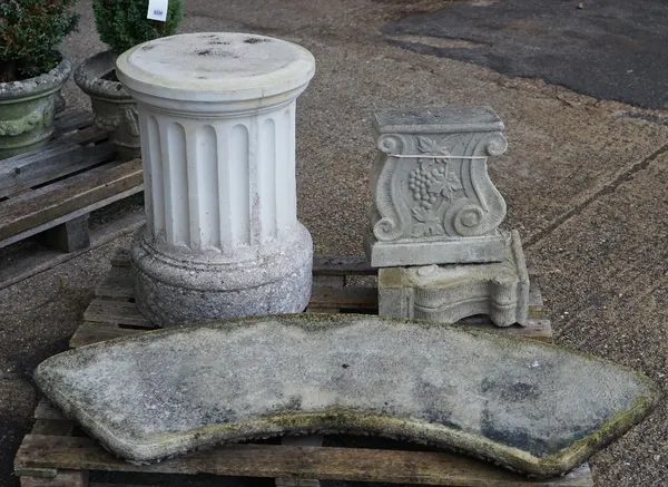 A reconstituted stone curved bench on a pair of scroll supports, 140cm wide, together with a reconstituted stone circular table on fluted plinth, 91cm