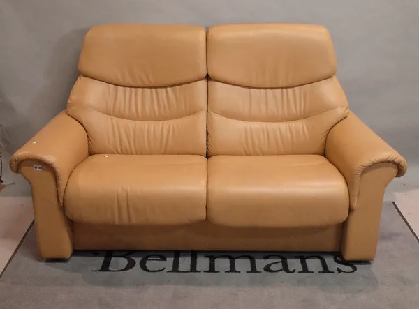 A contemporary two-seater reclining sofa, in tan leather, 128cm wide.