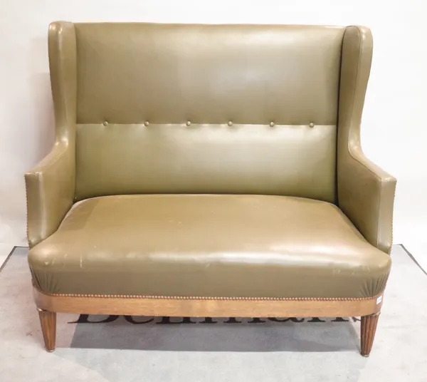 An early 20th century oak framed wingback two seater sofa on reeded tapering supports, 128cm wide x 111cm high.