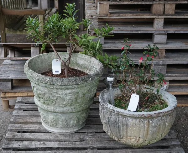 An early 20th century reconstituted stone circular planter with egg and dart decoration, 55cm diameter x 49cm high and another reconstituted stone jar