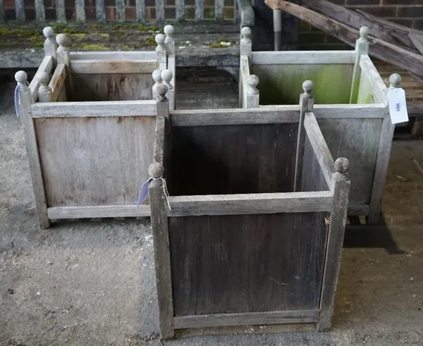 A set of three Versailles style teak square planters, 55cm wide x 65cm high, together with one similar smaller, 45cm wide x 56cm high, (4)