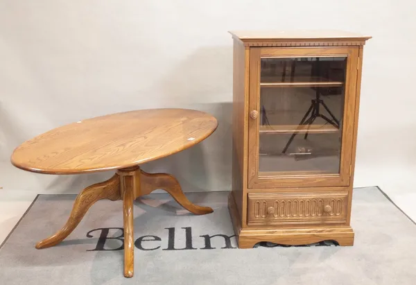 'ERCOL' ; A modern oval coffee table on four downswept supports, 122cm wide x 51cm high, and a matching 'ERCOL' side cabinet, 55cm wide x 97cm high (2