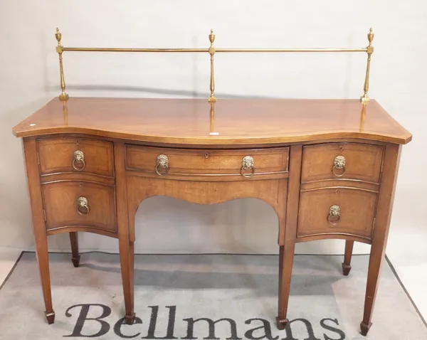 A George III style mahogany serpentine sideboard,the single drawer flanked by cupboards on tapering square supports, 152cm wide x 127cm high