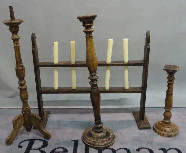 A group of three modern stained beech candlesticks the tallest 89cm high and a late 19th century stained pine candle holder, 88cm wide x 66cm high (4)