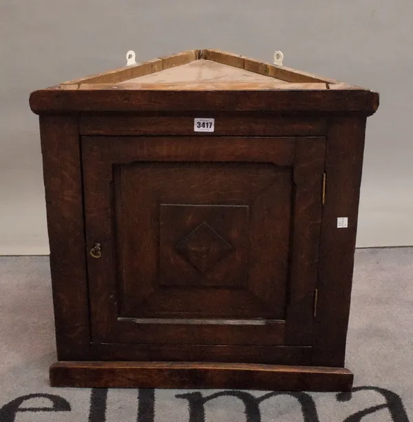 An early 20th century stained beech hanging corner cupboard, 54cm wide x 56cm high.