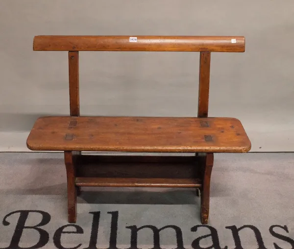 An early 20th century stained pine child's bench, 91cm wide x 77cm high.