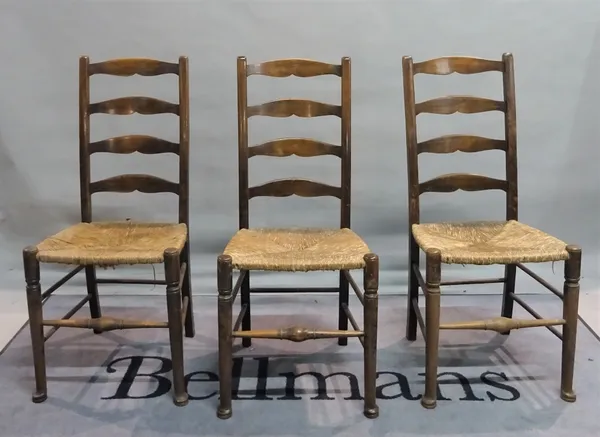 A set of five early 20th century stained beech ladderback dining chairs, 44cm wide x 99cm high, and a pair of early 20th century oak highback open arm