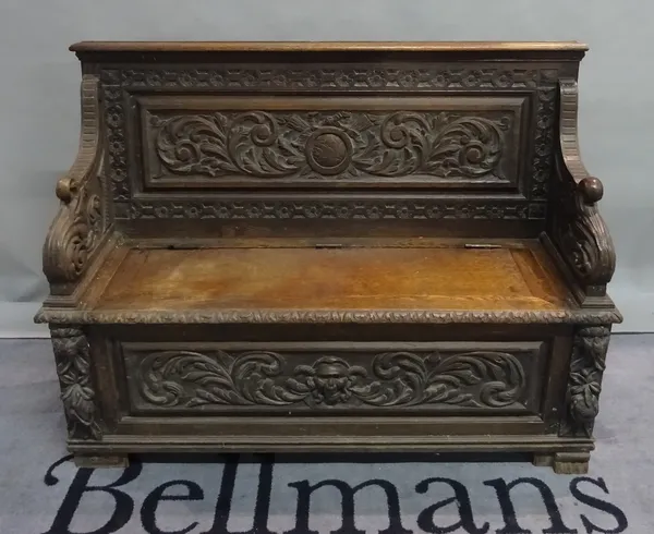 An 18th century style carved oak monk's bench, 122cm wide x 91cm high.