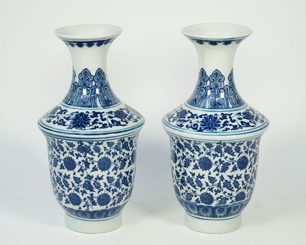 A pair of modern Chinese style blue and white porcelain vases, each foliate decorated against a shaped ground, printed marks to base, 31.5cm high, (2)