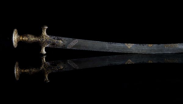 An early 19th century Indian gold inlaid Tulwar sword, with curved Damascened blade, the gold inlaid handle decorated with flowers and leaves, 94cm lo