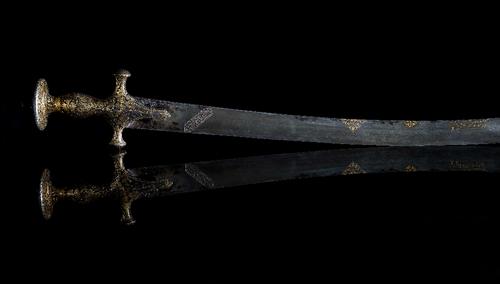 An early 19th century Indian gold inlaid Tulwar sword, with curved Damascened blade, the gold inlaid handle decorated with flowers and leaves, 94cm lo