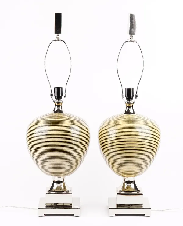 A pair of modern ceramic table lamps of ovoid form, raised on stepped chrome bases, with shades, 55cm high.