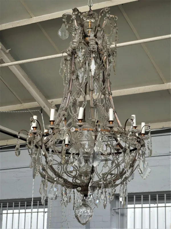 A large gilt metal, glass and cut glass chandelier in the the 18th century style, with twelve candle nozzles, pear shaped finial and vasiform reservoi