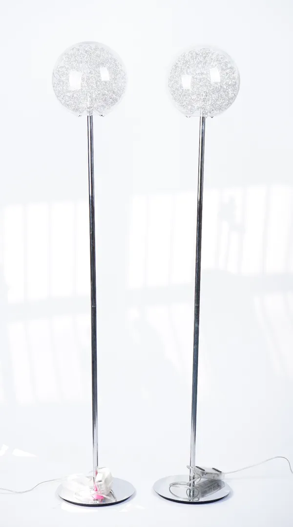 A pair of modern chrome floor standing lamps, with wire filled globular glass shades, 154cm high.