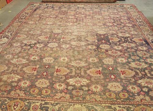 A 19th century Agra carpet, Indian, the aubergene field with an allover floral design of palmettes and other flower heads; a complementary border, 414