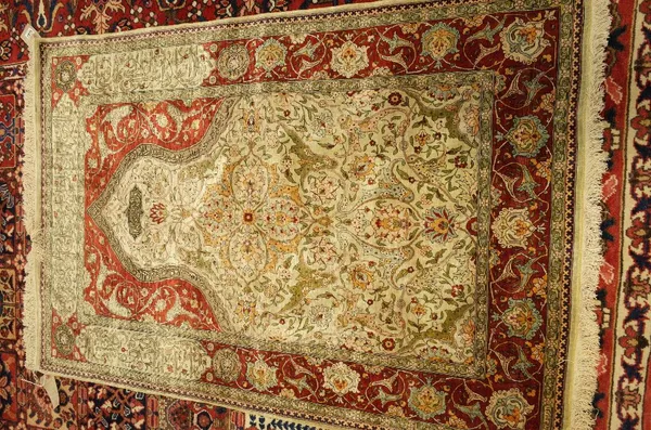 A fine silk keyseri prayer rug, Turkish, the ivory mehrab filled with palmettes, lilies and floral sprays, with metal thread inscription to top; a mad