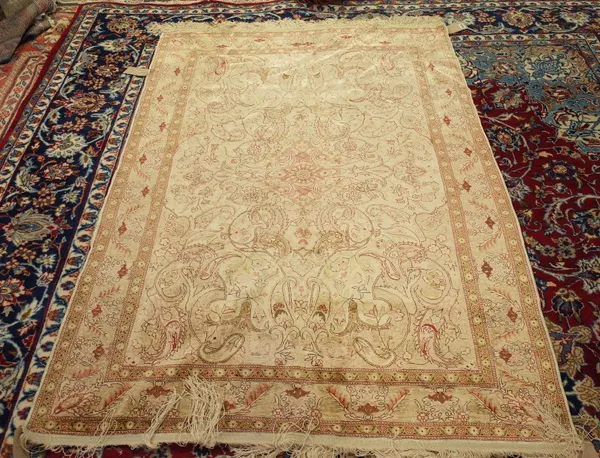 A Hereke silk rug, Turkish, the ivory field with a pale madder shaped medallion, pale pink spandrels; a matching pale pink leaf and palmette border, 1