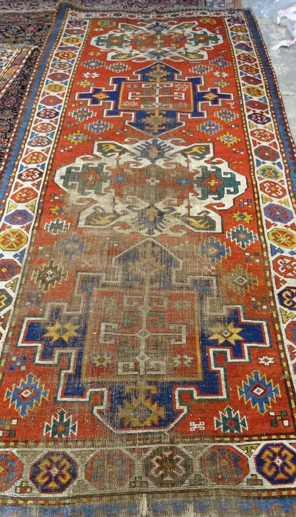 A Kazakh rug, Caucasian, the madder field with two large ivory and two large indigo medallions, stepped motifs, an ivory medallion border, 284cm x 127