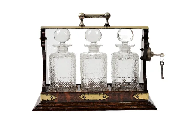 An early 20th century oak and silver plate mounted three bottle tantalus, 39cm wide x 31cm high.