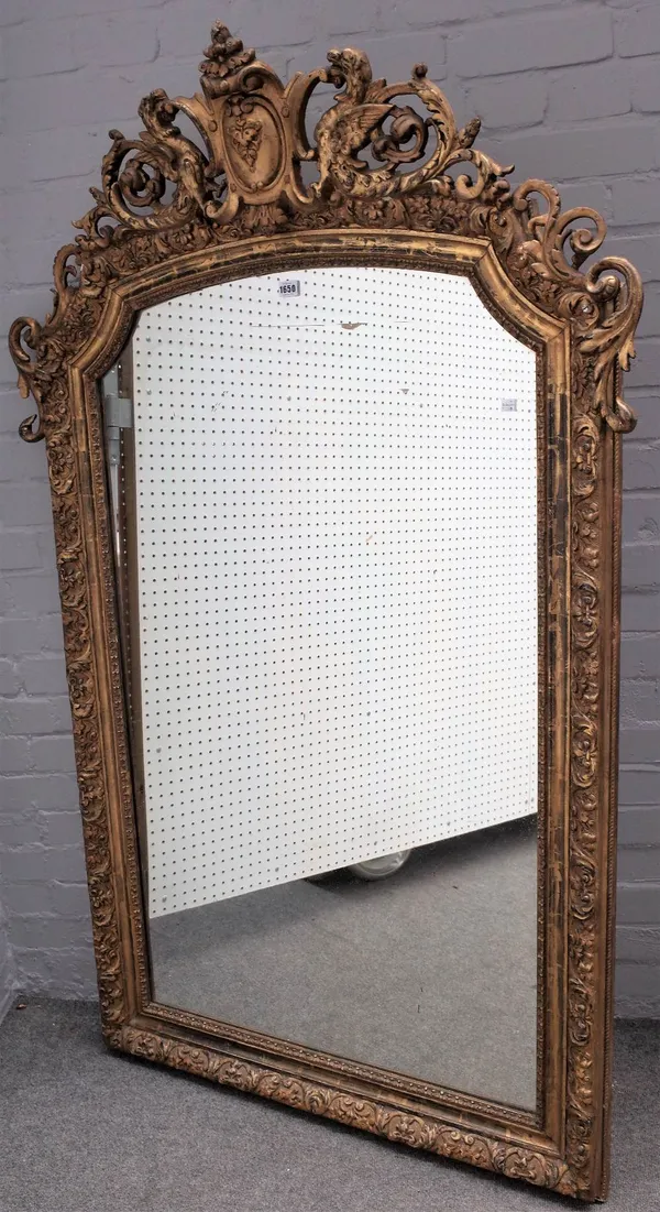 A 19th century French gilt framed arch top mirror, with cartouche crest and floral chased frame, 103cm wide x 167cm high.