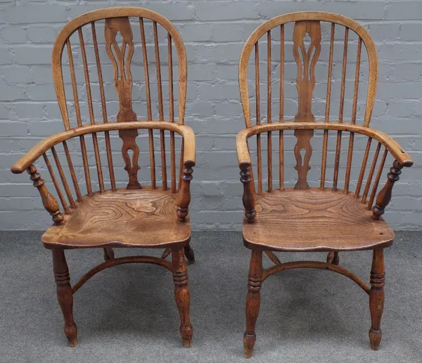 A pair of ash and elm Windsor elbow chairs, 19th century, the high backs with pierced splats, on ring turned legs united by crinoline stretchers, appr