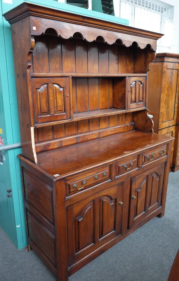 An 18th century style fruitwood dresser, the enclosed two tier plate rack, with a pair of cupboards, over three drawers and pair of arch panel cupboar