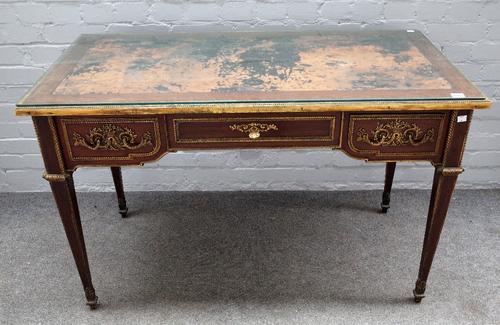 A Louis XVI style mahogany ormolu mounted bureau plat, stamped Mellier & Co, London, with inset rectangular top, having cast spiral and leaf borders,