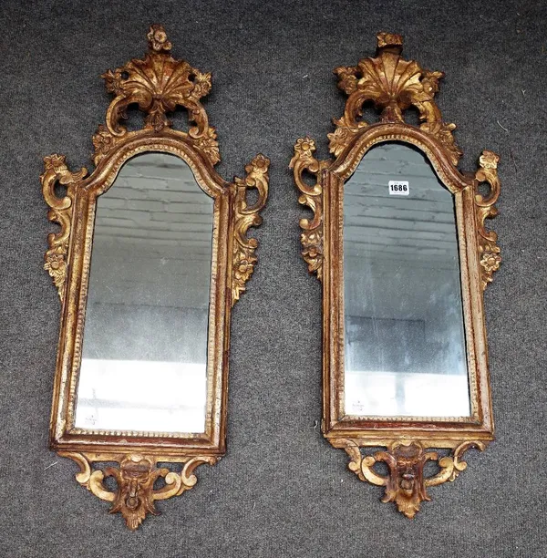 A pair of late 18th/early 19th century Venetian gilt framed wall mirrors, with shell and floral carved decoration about the arched mirror plate, 34cm