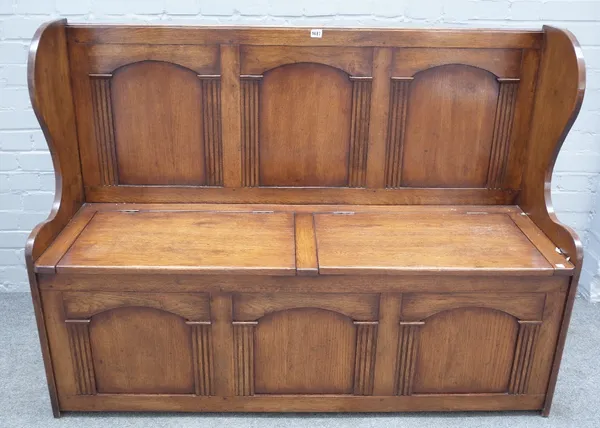 An 18th century style oak triple arch panel back box seat settle, 144cm wide x 107cm high.