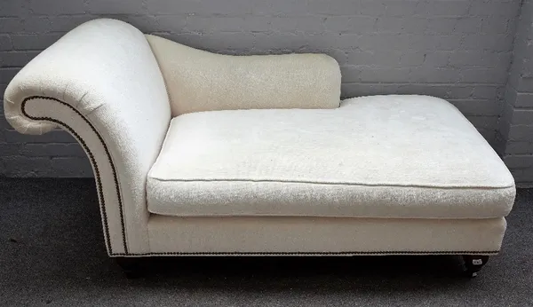 'Milling Road, A division of Baker Funiture'; a modern cream cotton upholstered brass studded daybed, on onion shaped supports, 170cm wide x 84cm high