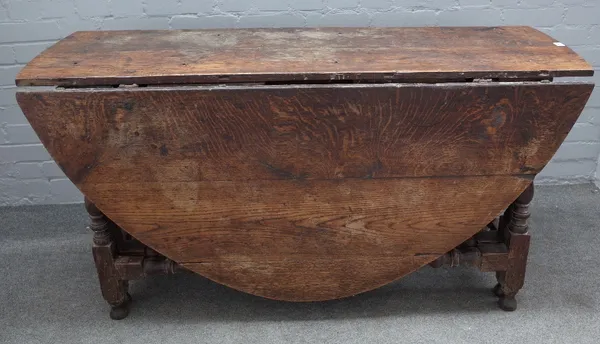 A 17th century oak double gateleg dropflap dining table on baluster turned supports, 146cm wide x 74cm high.