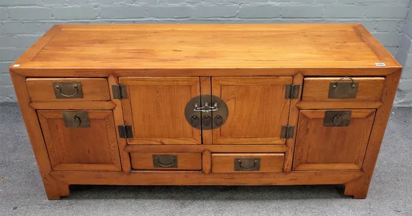 A 19th century Chinese elm low cabinet, with a pair of cupboards and six drawers, on bracket feet, 137cm wide x 63cm wide.