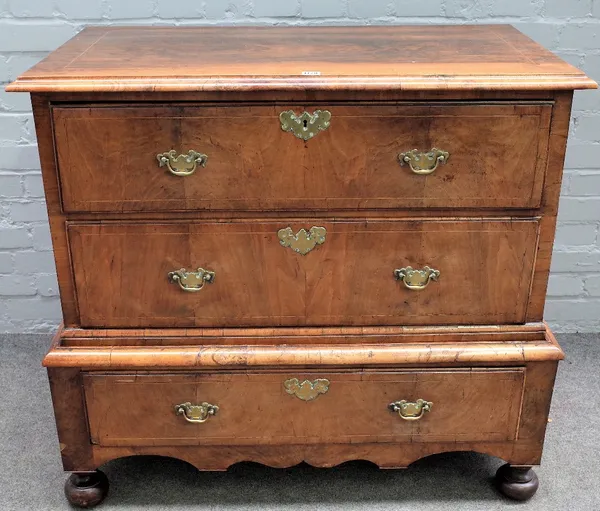 A George I walnut chest on stand, the pair of drawers over a single drawer base, on bun feet, 102cm wide x 92cm high.