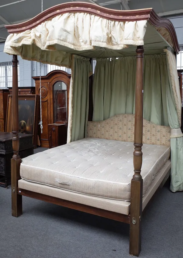 A reproduction George III style mahogany four poster bed, with arched painted and gilded canopy and ruched tented ceiling, vase and ring turned column