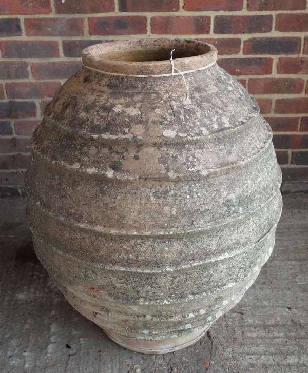 A large terracotta oil jar with ribbed body, 60cm diameter x 75cm high.