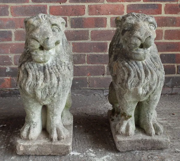 A pair of reconstituted stone figures of sejent lions, on square bases, 54cm high.