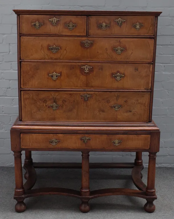 An early 18th century crossbanded walnut chest on stand, with two short over three long graduated drawers, the later stand with single drawer on turne