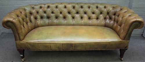 A Victorian style green leather upholstered tub back Chesterfield style sofa, on turned mahogany supports, 174cm wide x 84cm high.