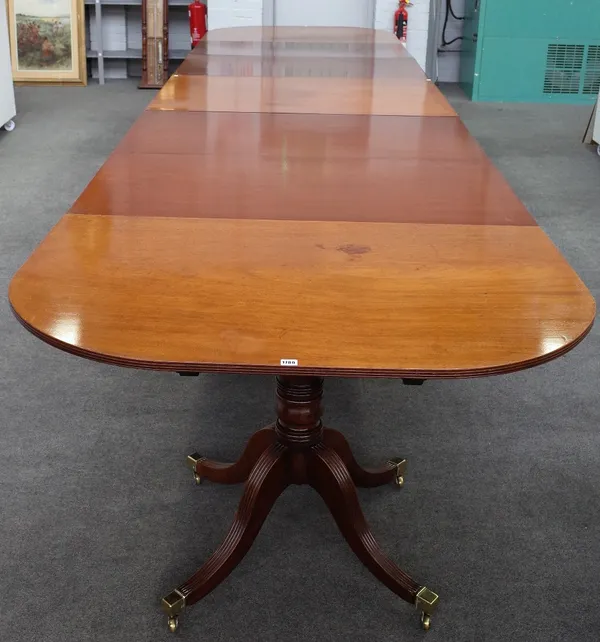 A Regency style mahogany triple pillar extending dining table, on twelve channelled downswept supports, with four extra leaves, 132cm wide x 253cm lon