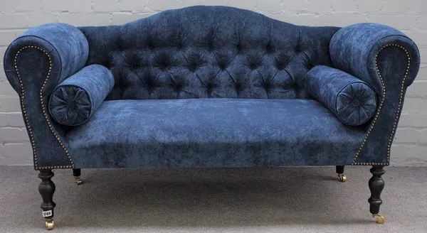 A Regency style studded blue upholstered hump back sofa, of small proportions, on turned ebonised supports, 140cm wide x 78cm high.